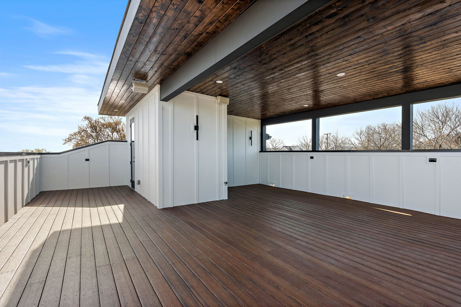 Black-stained covered deck with wood-plank ceiling and Nashville skyline view on a Mark Lynn Design contemporary home
