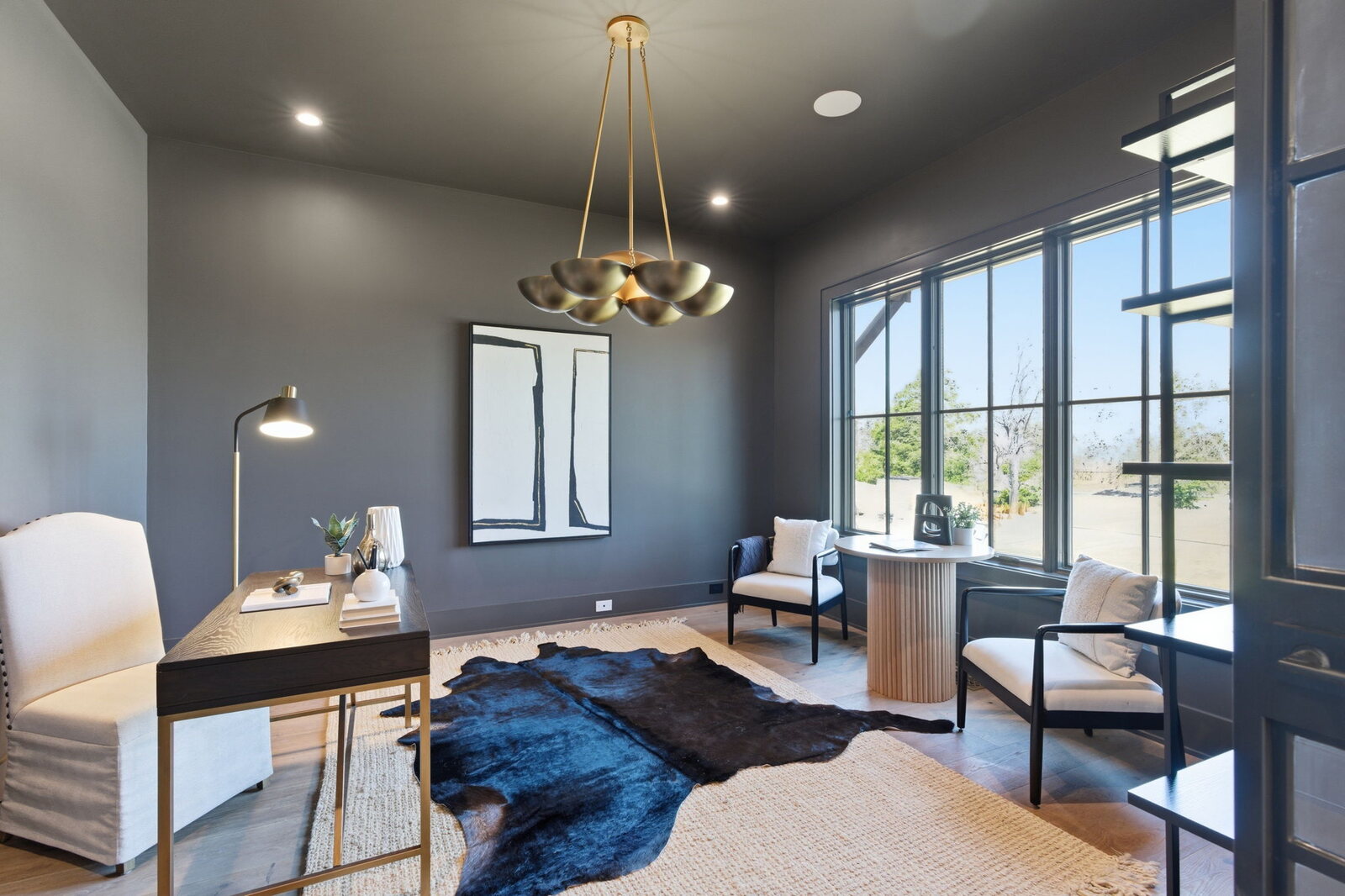 Dining room with round table, chandelier, and black steel door in a Mark Lynn Design transitional farmhouse